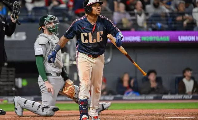 Cleveland Guardians' Jose Ramirez, right, watches his solo home run off Athletics relief pitcher Seth Johnson as Athletics catcher Jonah Heim, left, looks on during the sixth inning of a baseball game, Friday, Sept. 18, 2026, in Cleveland. (AP Photo/Phil Long)
