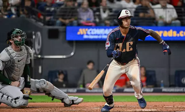 Cleveland Guardians' Brayan Rocchio, right, watches his two-run double off Athletics starting pitcher Mason Barnett as Athletics catcher Jonah Heim, left, looks on during the fourth inning of a baseball game, Friday, Sept. 18, 2026, in Cleveland. (AP Photo/Phil Long)