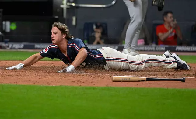 Cleveland Guardians' Petey Halpin slides safely across home plate on a double hit by Brayan Rocchio during the fourth inning of a baseball game against the Athletics, Friday, Sept. 18, 2026, in Cleveland. (AP Photo/Phil Long)