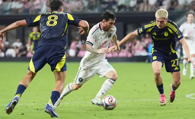 Nashville midfielder Patrick Yazbek (8) and defender Reed Baker-Whiting (27) defend Inter Miami forward Lionel Messi (10) during the second half of an MLS soccer match, Saturday, Sept. 12, 2026, in Miami. (AP Photo/Marta Lavandier)