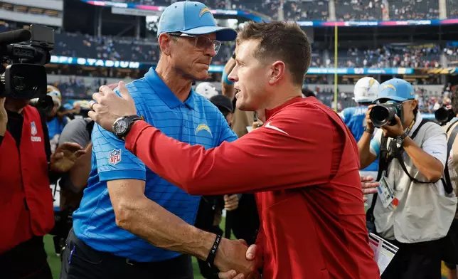 Los Angeles Chargers head coach Jim Harbaugh, left, greets Arizona Cardinals head coach Mike LaFleur after an NFL football game, Sunday, Sept. 13, 2026, in Inglewood, Calif. (AP Photo/Caroline Brehman)