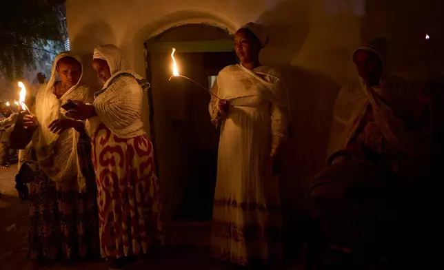 Ethiopian Orthodox Christian worshippers hold candles on the eve of the Meskel holiday at the Ethiopian monks' village, Deir Al‑Sultan, located on the rooftop of the Church of the Holy Sepulcher in Jerusalem's Old City, Saturday, Sept. 26, 2026. (AP Photo/Ohad Zwigenberg)