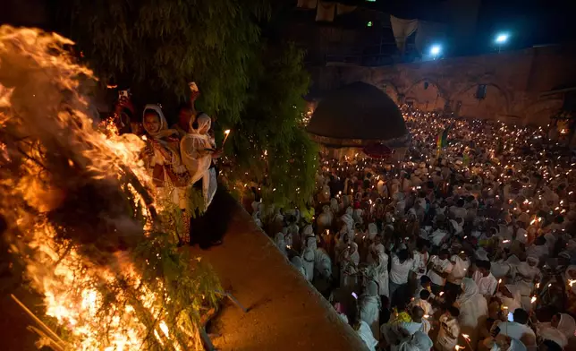 Ethiopian Orthodox Christian worshippers hold candles on the eve of the Meskel holiday at the Ethiopian monks' village, Deir Al‑Sultan, located on the rooftop of the Church of the Holy Sepulcher in Jerusalem's Old City, Saturday, Sept. 26, 2026. (AP Photo/Ohad Zwigenberg)