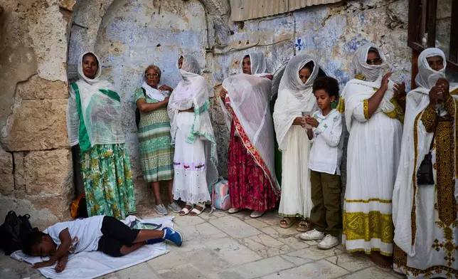 Ethiopian Orthodox Christian worshippers gather for celebrations on the eve of the Meskel holiday at the Ethiopian monks' village, Deir Al‑Sultan, located on the rooftop of the Church of the Holy Sepulcher in Jerusalem's Old City, Saturday, Sept. 26, 2026. (AP Photo/Ohad Zwigenberg)