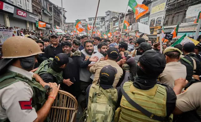 Police and paramilitary soldiers try to stop activists of Bharatiya Janata Party (BJP) during a protest against the National Conference (NC)-led regional government over rising electricity tariffs, unemployment and alleged governance failures in Srinagar, Indian-controlled Kashmir, Wednesday, Sept. 2, 2026. (AP Photo/Mukhtar Khan)