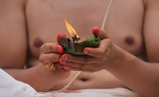 Sahas Pyakurel, whose mother remain missing and is presumed dead following flash floods, performs rituals during symbolic last rites on the banks of the swollen Trishuli River in Nepal's Nuwakot district, Wednesday, Sept. 2, 2026. (AP Photo/Rajesh Kumar Singh)