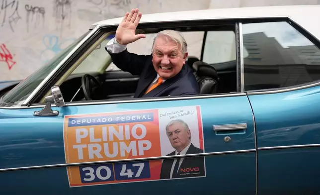 Plinio Vicentin Jr., who is running for federal lawmaker as "Plinio Trump," with the Novo Party representing Minas Gerais state, campaigns from his car ahead of the general election in Juiz de Fora, Minas Gerais state, Brazil, Monday, Sept. 28, 2026. (AP Photo/Silvia Izquierdo)