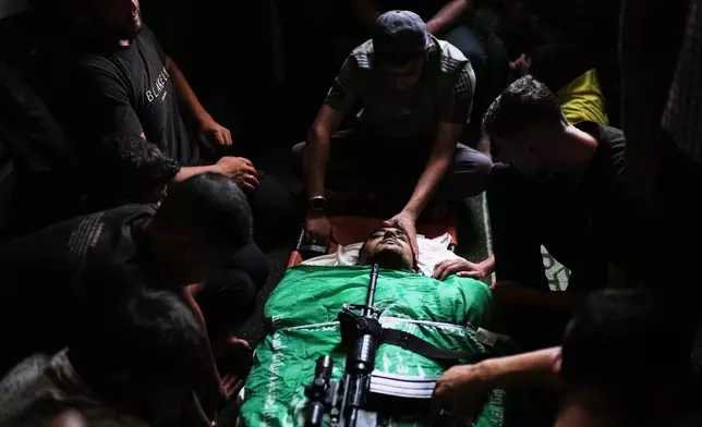 Palestinians mourn around the body of Hamas militant Mohannad Abu Foul, draped in the group's flag with a rifle placed on top, during his funeral after he was killed in an Israeli airstrike, in Gaza City, Tuesday, Sept. 29, 2026. (AP Photo/Jehad Alshrafi)
