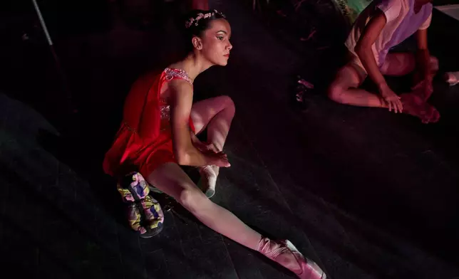 A dancer from the National Ballet of Cuba adjusts her ballet shoes before rehearsal in Havana, Cuba, Friday, Aug. 21, 2026. (AP Photo/Ramon Espinosa)