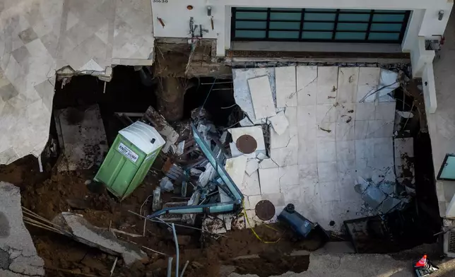 An aerial view of a sinkhole which collapsed the driveway of a coastal mansion owned by actor Nicolas Cage Tuesday, Sept. 8, 2026, in Malibu, Calif. (AP Photo/Ethan Swope)