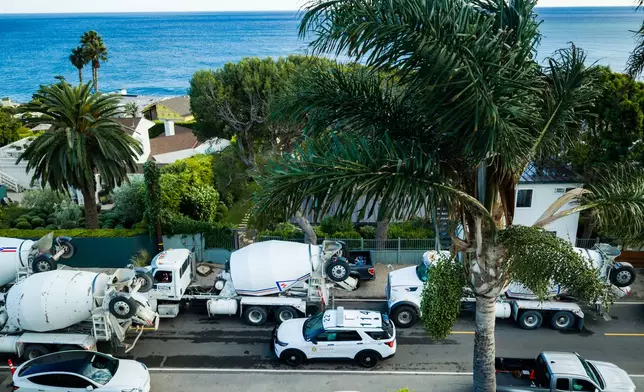 An aerial view construction vehicles lined up near a sinkhole which collapsed the driveway of a coastal mansion owned by actor Nicolas Cage Tuesday, Sept. 8, 2026, in Malibu, Calif. (AP Photo/Ethan Swope)
