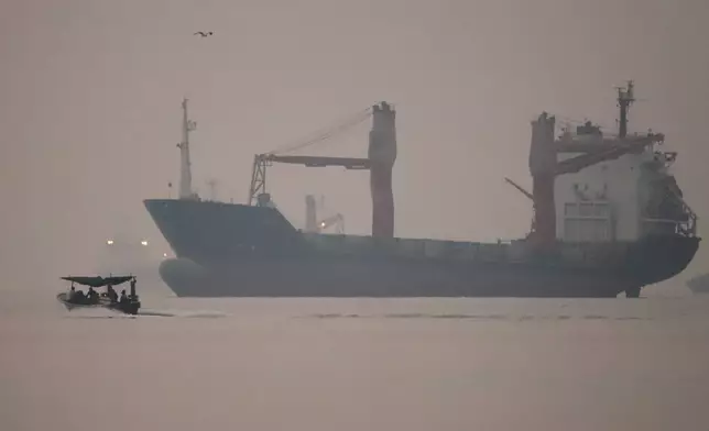 A motorboat passes an anchored cargo ship in the Strait of Hormuz off Bandar Abbas, Iran, early Monday, Sept. 28, 2026. (Amirhosein Khorgooi/ISNA via AP)