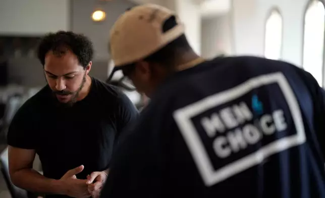 Jeremiah Simmons looks over information at the Men 4 Choice table at Bridgepointe Church during an event, Wednesday, Sept. 16, 2026, in Marietta, Ga. (AP Photo/Mike Stewart)