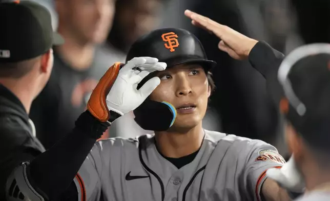San Francisco Giants' Jung Hoo Lee is congratulated by teammates in the dugout after hitting a solo home run during the second inning of a baseball game against the Los Angeles Dodgers, Friday, Sept. 18, 2026, in Los Angeles. (AP Photo/Mark J. Terrill)