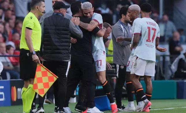 Shakhtar's Gleiker Mendoza, center, hugs his coach Arda Turan after scoring the opening goal during the Champions League opening phase soccer match between PSV and Shakhtar in Eindhoven, Netherlands, Thursday, Sept. 10, 2026. (AP Photo/Patrick Post)