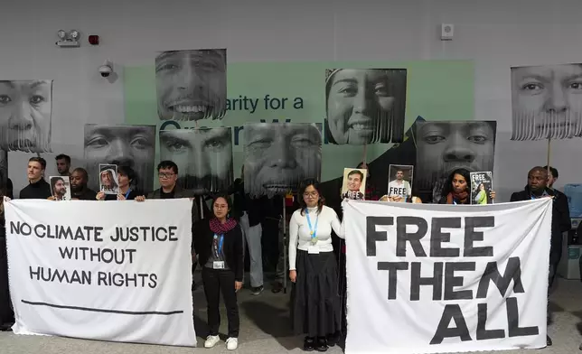 FILE - Demonstrators hold signs with images of environmental defenders during the COP29 U.N. Climate Summit, Nov. 20, 2024, in Baku, Azerbaijan. (AP Photo/Joshua A. Bickel, File)