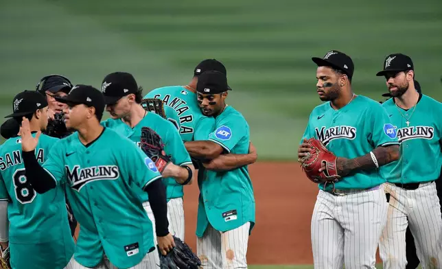 Miami Marlins Sandy Alcantara hugs Esteury Ruiz after beating the Atlanta Braves in a baseball game, Sunday, Sept. 27, 2026, in Miami. (AP Photo/Michael Laughlin)