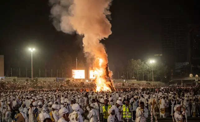 People chant as the bonfire lights during celebrations for the Orthodox holiday of Meskel, an annual holiday celebrating the discovery of the True Cross in the fourth century by the Roman Empress Helena, in Addis Ababa, Ethiopia, Saturday, Sept. 26, 2026. (AP Photo/Amanuel Sileshi)