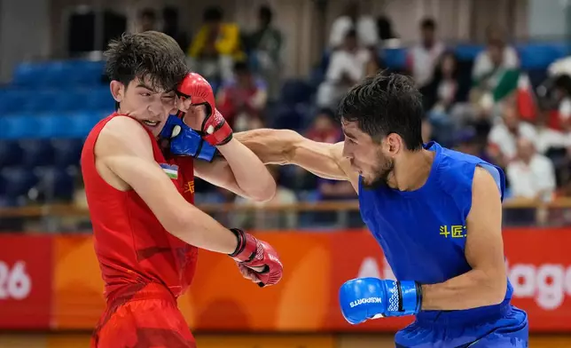 Firdaus Atamuratov of Uzbekistan, left, competes with Mirzobek Umarov of Tajikistan during their men's modern 60kg mixed martial arts final at the Asian Games in Nagoya, Japan, Tuesday, Sept. 22, 2026. (AP Photo/Dita Alangkara)