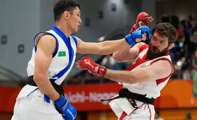 Mukhammad Nabiev of Bahrain, right, competes against Yerkingali Burkutalin of Kazakhstan during their men's traditional 77kg mixed martial arts final at the Asian Games in Nagoya, Japan, Tuesday, Sept. 22, 2026. (AP Photo/Dita Alangkara)