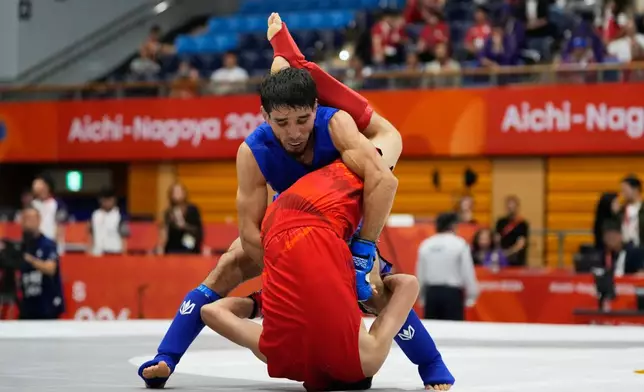 Firdaus Atamuratov of Uzbekistan, bottom, competes with Mirzobek Umarov of Tajikistan during their men's modern 60kg mixed martial arts final at the Asian Games in Nagoya, Japan, Tuesday, Sept. 22, 2026. (AP Photo/Dita Alangkara)