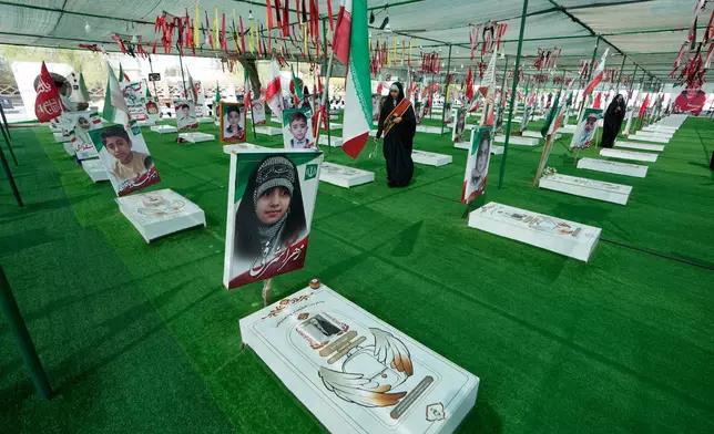 A woman walks at the graveyard of the school children who were killed after their school was a hit by a strike on Feb. 28, in town of Minab in southern Iran, Saturday, Sept. 5, 2026. (AP Photo/Vahid Salemi)