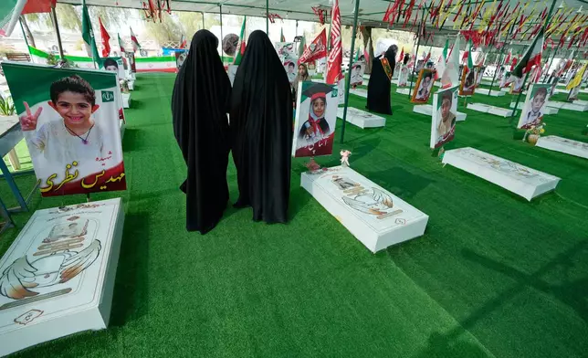 Women walk at the graveyard of the school children who were killed after their school was a hit by a strike on Feb. 28, in town of Minab in southern Iran, Saturday, Sept. 5, 2026. (AP Photo/Vahid Salemi)