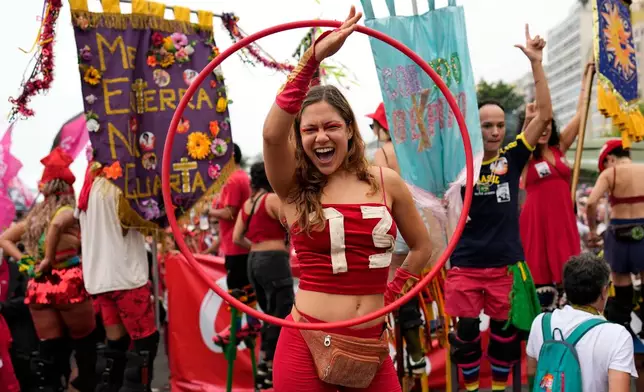 A supporter wearing a shirt bearing Brazilian President Luiz Inacio Lula da Silva's campaign number 13 takes part in a carnival party in support of Lula, who is running for reelection, on Copacabana beach in Rio de Janeiro, Brazil, Sunday, Sept. 27, 2026. (AP Photo/Silvia Izquierdo)