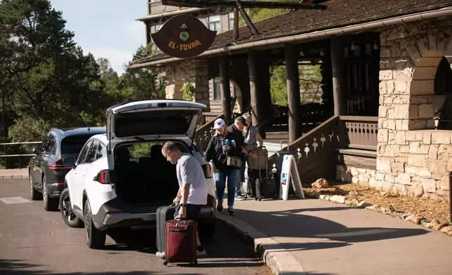 Tourists check out of the El Tovar Hotel as lodging along the rim of the canyon was shut down due to flooding, Monday, Aug. 31, 2026 at Grand Canyon National Park, Ariz. (AP Photo/Josh Biggs)