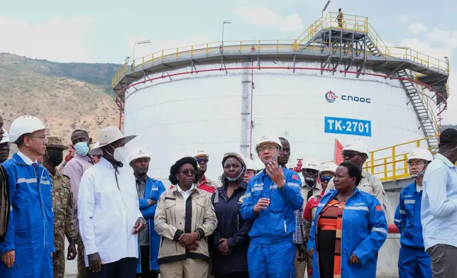 CNOOC President Dr. Liu Xiangdong, center, talks to Ugandan President Yoweri Museveni during a tour of the central processing unit at the Kingfisher oil field near Hoima, Uganda, Wednesday, Sept. 2, 2026. (AP Photo/Hajarah Nalwadda)