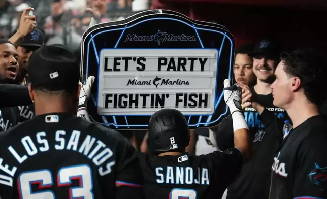 Miami Marlins' Javier Sanoja celebrates with teammates after hitting a solo home run against the Arizona Diamondbacks in the fourth inning of a baseball game, Monday, Sept 14, 2026, in Phoenix. (AP Photo/Rick Scuteri)