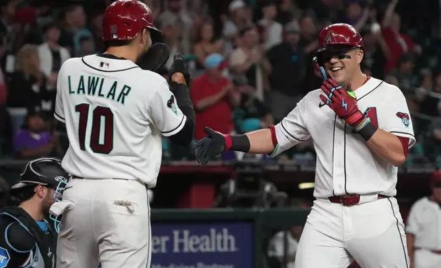 Arizona Diamondbacks' Lars Nootbaar, right, celebrates with center fielder Jordan Lawlar (10) after hitting a two-run home run against the Miami Marlins in the third inning of a baseball game, Monday, Sept 14, 2026, in Phoenix. (AP Photo/Rick Scuteri)