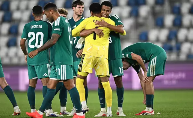 Northern Ireland's Shea Charles embraces Northern Ireland's goalkeeper Pierce Charles, back to a camera, celebrating after scoring his side's opening goal during the Nations League soccer match between Georgia and Northern Ireland in Tbilisi, Georgia, Friday, Sept. 25, 2026. (AP Photo/Tamuna Kulumbegashvili)