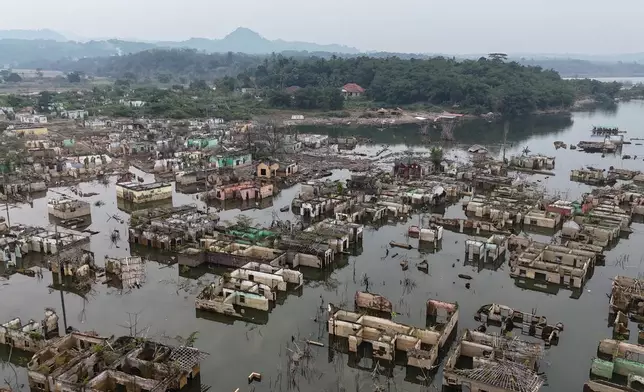 Long-submerged houses are exposed after prolonged drought lowers the water level of Karian Dam, in Lebak, Banten Province, Indonesia, Friday, July 31, 2026. (AP Photo/Tatan Syuflana)