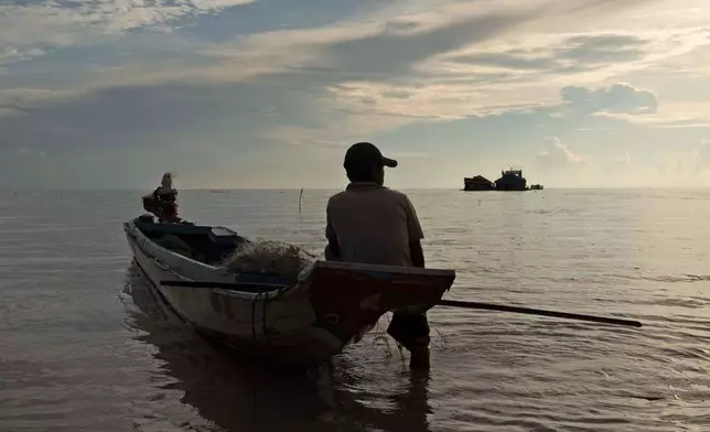 FILE- A fisherman sits on a boat in the Tonle Sap lake, Siem Reap, Cambodia, Friday, Aug. 2, 2024. (AP Photo/Aniruddha Ghosal, File)