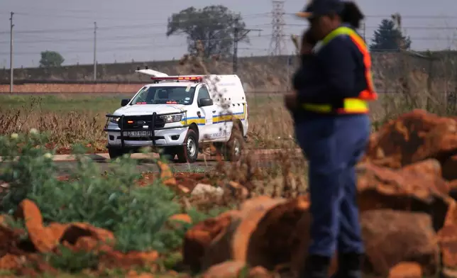 Forensic investigators work at the site where the body of a woman was discovered on the outskirts of Johannesburg, South Africa, Thursday, Sept. 17, 2026. (AP Photo/Themba Hadebe)