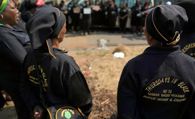 A women's church group pay their respect at a scene of a discovery of the body of a 38-year-old woman last week while jogging, in Kempton Park, east of Johannesburg, South Africa, Thursday, Sept. 17, 2026. (AP Photo/Themba Hadebe)