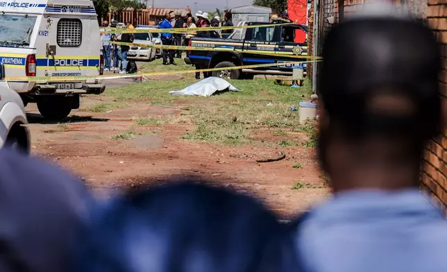 A body, believed to be that of a woman, is found along a road in KwaThema, Springs, South Africa, Tuesday, Sept. 15, 2026. (AP Photo)