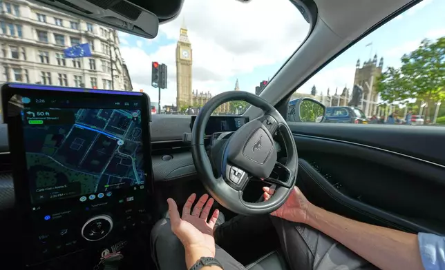An Uber driver has his hands ready for intervention as he sits in an autonomous car in London, Tuesday, Sept. 1, 2026 as Uber officially launches the first hailable autonomous cabs in London.(AP Photo/Frank Augstein)