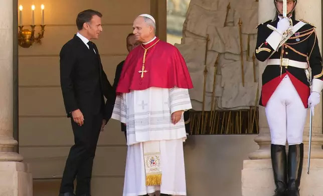 Pope Leo XIV, right, is welcomed by French President Emmanuel Macron at the Elysee Palace as part of his four-day pastoral visit to France, Friday, Sept. 25, 2026. (AP Photo/Teresa Suarez, Pool)