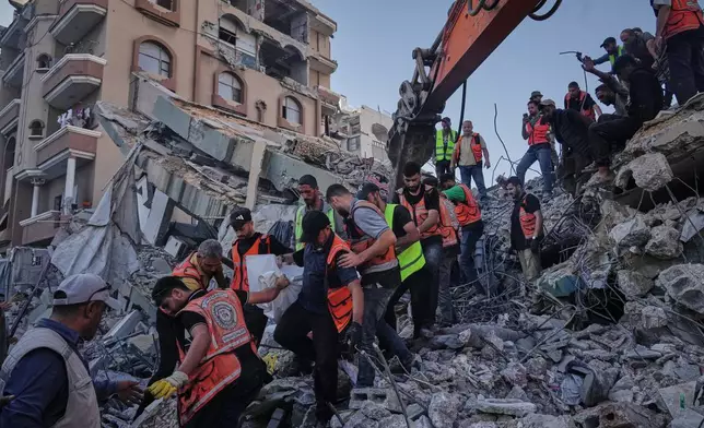 Palestinian civil defense crews carry a body from the rubble of a collapsed building that housed displaced Palestinians and was heavily damaged during the Israel-Hamas war, in Gaza City, Wednesday, Sept. 16, 2026. (AP Photo/Jehad Alshrafi)