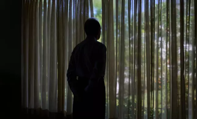 Simon, who was targeted by a scammer that stole $800,000 from his retirement savings and asked not to be identified by his full name because he's too ashamed to tell most of his family about the crime, looks out a window from his home, Wednesday, June 17, 2026, at his home in southeastern New York. (AP Photo/David Goldman)