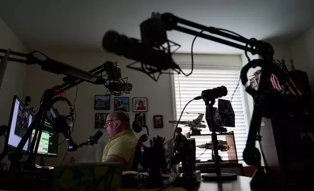 Brian Glick, who is fighting to recover the $575,000 stolen from him by a scammer online, joins a group call with other scam victims at his home where he also produces a podcast on the subject, Wednesday, June 25, 2025, in Ballston Lake, N.Y. (AP Photo/David Goldman)