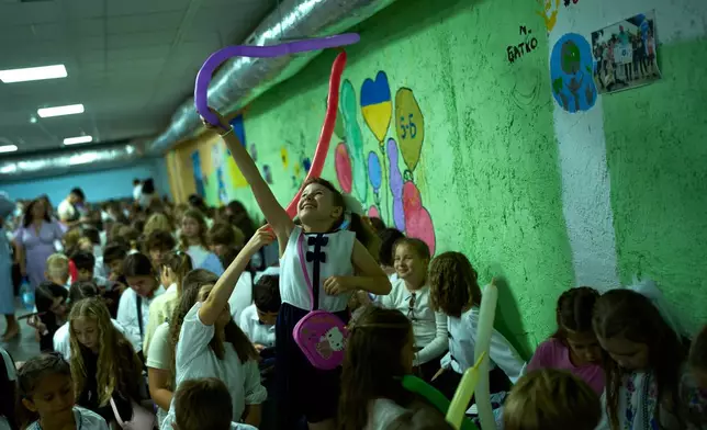 Children play in an underground shelter during an air raid alarm during the traditional back to school celebrations in Kyiv, Tuesday, Sept. 1, 2026. (AP Photo/Francisco Seco)