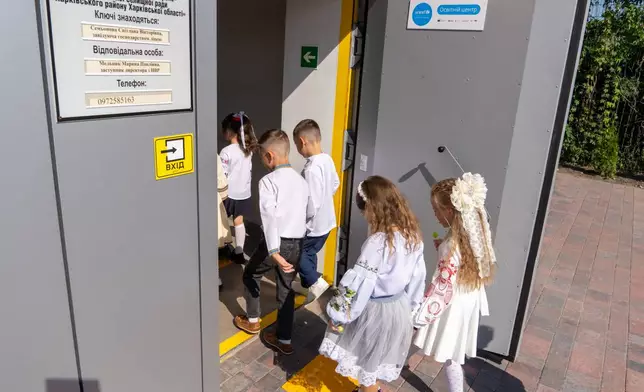 School children enter an underground school on their first day back, in Kharkiv, Ukraine, Tuesday, Sept. 1, 2026. (AP Photo/Andrii Marienko)