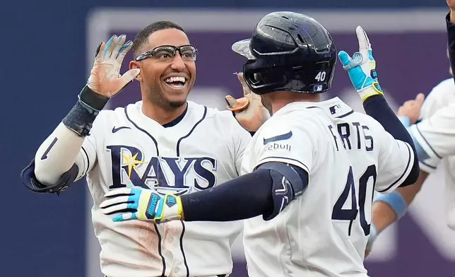 Tampa Bay Rays' Richie Palacios, left, celebrates his walkoff single off Boston Red Sox pitcher Garrett Whitlock with Nick Fortes during a baseball game Saturday, Sept. 19, 2026, in St. Petersburg, Fla. (AP Photo/Chris O'Meara)