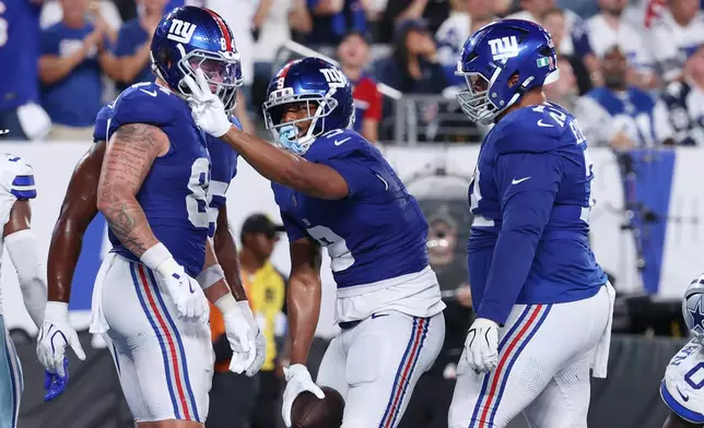 New York Giants tight end Isaiah Likely, center, gestures after scoring a touchdown against the Dallas Cowboys during the second half of an NFL football game Sunday, Sept. 13, 2026, in East Rutherford, N.J. (AP Photo/Pamela Smith)
