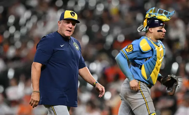 Milwaukee Brewers manager Pat Murphy, left, walks to the dugout after a pitching change against the Baltimore Orioles in the seventh inning of a baseball game on Sunday, Sept. 20, 2026 in Baltimore. (AP Photo/Gail Burton)