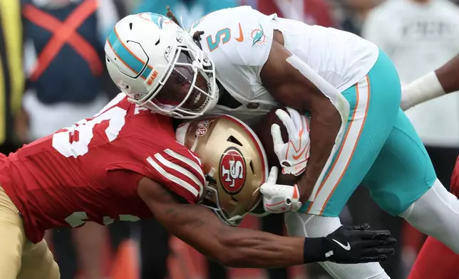 Miami Dolphins running back Jaylen Wright (5) is hit by San Francisco 49ers safety Marques Sigle during the first half of an NFL football game in Santa Clara, Calif., Sunday, Sept. 20, 2026. (AP Photo/Jed Jacobsohn)