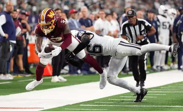 Washington Commanders wide receiver Stefon Diggs (3) makes a catch against Dallas Cowboys cornerback Daron Bland (26) in the first half during an NFL football game in Arlington, Texas, Sunday, Sept. 20, 2026. (AP Photo/Tony Gutierrez)